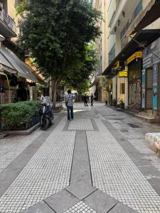 a person standing on a street in a city at Shape Suites Athens in Athens
