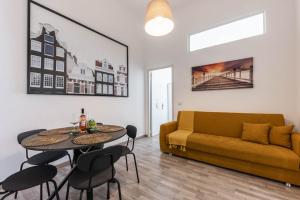 a living room with a couch and a table and chairs at SUN HOUSE in Bari