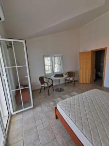 a bedroom with a bed and a table and chairs at Villa Sunset in Mandre