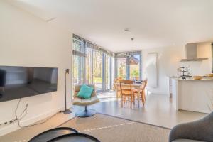 Una sala de estar con cocina y comedor. en De Wadden Parel - Villa 184, en Den Burg