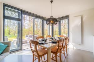 Un comedor con mesa y sillas en De Wadden Parel - Villa 184, en Den Burg