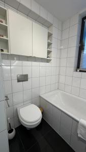 a white bathroom with a toilet and a tub at Wohnung Nähe TU Dortmund in Dortmund +25 photos