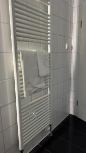 a mirror in a white tiled bathroom with a towel at Wohnung Nähe TU Dortmund in Dortmund