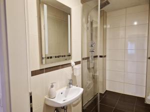 a bathroom with a sink and a shower at New City Center Stays 1 in Munich +49 photos