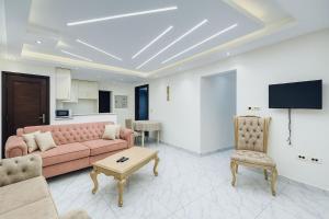 a living room with a pink couch and a tv at Beachfront Bliss Awaits You at Porto Said in Port Said