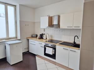 a kitchen with white cabinets and a stove top oven at New City Center Stays 1 in Munich