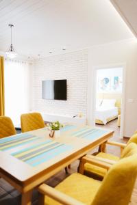 a living room with a table and yellow chairs at Luxury Apartment at Saranda Port in Sarandë