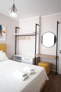 a bedroom with a bed with a mirror and a chair at Luxury Apartment at Saranda Port in Sarandë