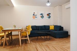 a living room with a blue couch and a table at Luxury Apartment at Saranda Port in Sarandë