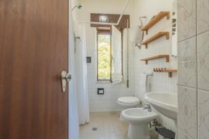 un bagno con un water, un lavandino e una finestra di Riva Verde a Bolsena