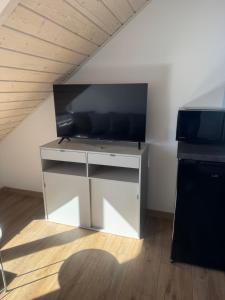 a large flat screen tv on a stand in a room at Apartamenty Niesiołowice na Kaszubach in Niesiołowice +4 photos