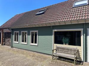 a bench in front of a small green building at Ride by the Sea Guesthouse in Koudekerke +33 photos