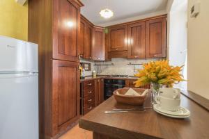una cucina con armadi in legno e un vaso di fiori su un bancone di Riva Verde a Bolsena Altre 11 foto