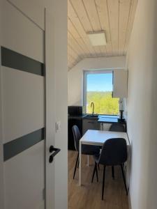 a room with a table and chairs and a window at Apartamenty Niesiołowice na Kaszubach in Niesiołowice