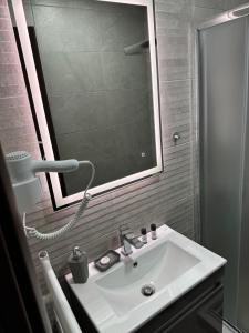 a bathroom with a white sink and a mirror at Eretria apartment in Eretria +7 photos