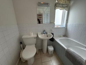 a bathroom with a toilet and a sink and a tub at Anchor Cottage in Seaview +21 photos