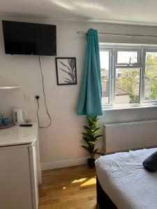 a bedroom with a bed and a green umbrella at Tulse Tavern in West Dulwich