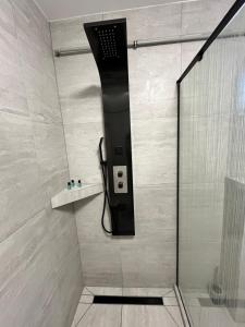 a shower with a black phone in a bathroom at 4ML Boutique Room in Debrecen +14 photos