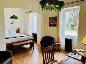 a bedroom with a bed and a desk and a chair at Domaine de charme sur lac privé in Dirac +28 photos