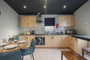 a kitchen with a table and a dining room at Extended Stays Welcome - Sleeps 11 - FREE Parking - Hosted by HG Horizon Properties in Doncaster