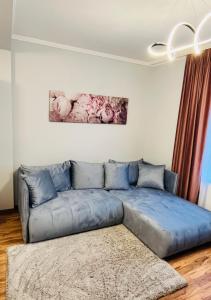 a living room with a blue couch in a room at 4ML Boutique Room in Debrecen