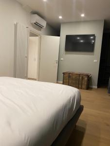 a bedroom with a white bed and a flat screen tv at Luxury Apartment, Downtown IMOLA, Italy in Imola +4 photos