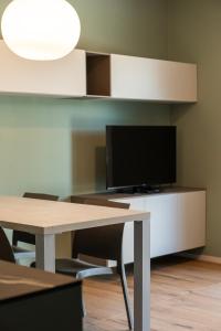 a room with a table with a tv and a tv stand at Casa Isabella2 in Ferrara