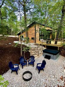 a group of chairs sitting in front of a cabin at NEW! Cedar Hill Cabin • 2bed •2bath•Hot Tub in Marble Falls