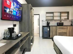 a kitchen with a counter and a tv on the wall at The Ivory Suites in Mombasa