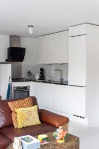 a living room with a couch and a kitchen at Lovely cozy houseboat Rembrandt, old centre Leiden in Leiden