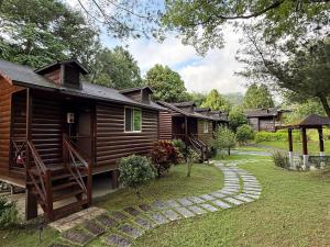 a row of wooden lodges with a pathway leading to a yard at 自在旅墅山莊 in Guoxing