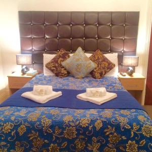 a bed with two pillows and a blue and white comforter at Metro Star in London