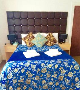 a bed with a blue comforter and pillows on it at Metro Star in London