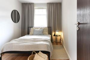 Un dormitorio pequeño con una cama y una ventana. en Klimatyczny apartament 3-pokojowy, en Olsztyn