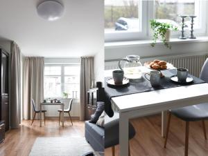 una cocina y una sala de estar con una mesa con comida. en Klimatyczny apartament 3-pokojowy, en Olsztyn
