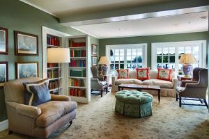 a living room with a couch and chairs and bookshelves at Inn at Perry Cabin in Saint Michaels
