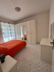 a bedroom with a bed with a red bedspread at Appartamento in villa in Forio d'Ischia