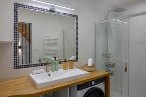 a bathroom with a sink and a mirror and a shower at La Maison Scandi-Loire Classée 3 étoiles à ORLEANS en bord de Loire - 3 chambres avec Garage in Orléans +27 photos