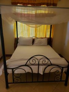 a bed in a room with a canopy bed at 2M lodge Tarangire in Manyara