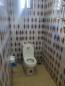 a small bathroom with a toilet in a room at 2M lodge Tarangire in Manyara