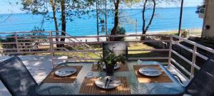 a table on a balcony with a view of the ocean at Villa Kiki by the beach! in Kokkino Nero