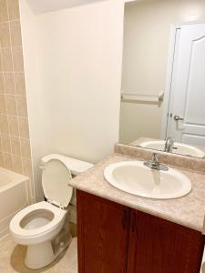 a bathroom with a sink and a toilet and a mirror at Private Bright Coach House - Near Pearson Airport & Downtown Toronto in Brampton +11 photos