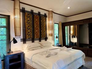a bedroom with a large white bed with a large mirror at The Green Palm in Haad Pleayleam