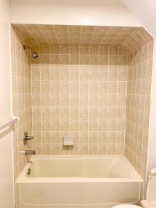 a bathroom with a tub and a toilet at Private Bright Coach House - Near Pearson Airport & Downtown Toronto in Brampton