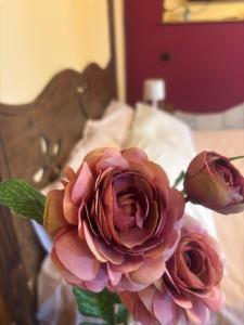two pink roses in a vase on a bed at Etna Winery in Zafferana Etnea