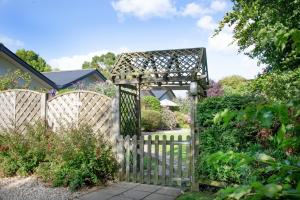 einen Holzzaun mit einem Tor im Garten in der Unterkunft Seagull Leigh Cottages in Seaton