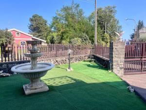 a fountain in the middle of a green lawn at Zafferana's Pool Retreat in Zafferana Etnea +16 photos