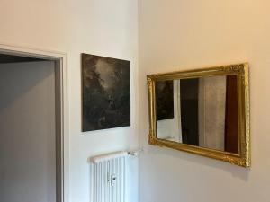 a mirror on a wall next to a painting at La Maison du Lac in Bissone