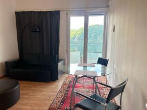 a living room with a glass table and a couch at La Maison du Lac in Bissone