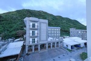 un edificio con una montagna sullo sfondo di 小島月光民宿 Moonlit Isle a Green Island